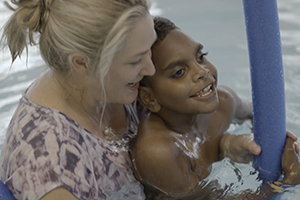 Woman in hydrotherapy pool with young boy