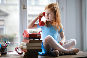 Little girl talking on an old school telephone