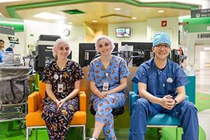 Three surgical staff sitting next to each other in scrubs