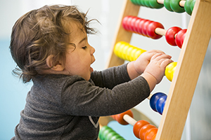 Toddler playing with an abacus