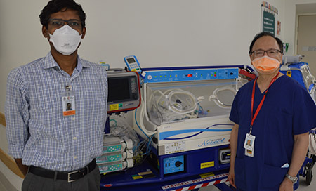 Dr Sam Athikarisamy and Professor Geoffrey Lam in front of a neonate humicrib